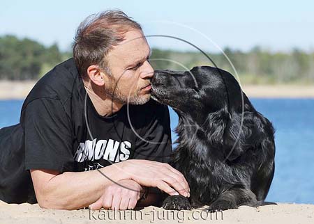 Flatcoated Retriever Senior küsst Herrchen